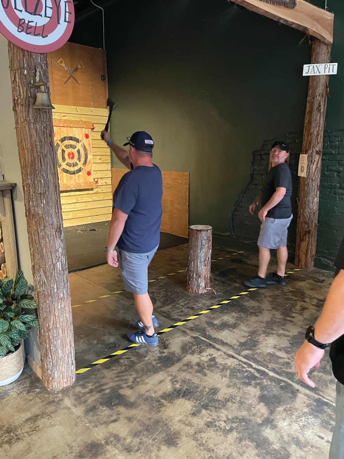 Customers participate in an axe-throwing game. The Jacksonville location has seven throwing pits that can hold up to groups of 10.